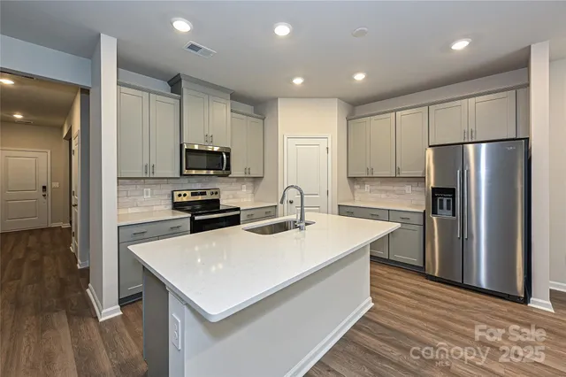 a kitchen with a refrigerator a stove top oven a sink and a center island