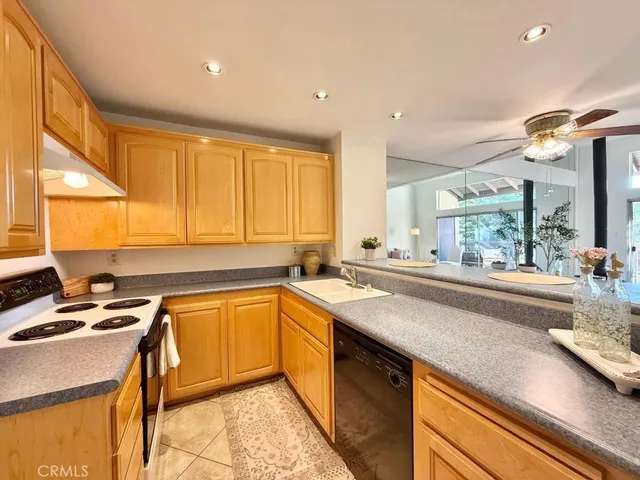 a kitchen with a sink a counter top space cabinets and appliances