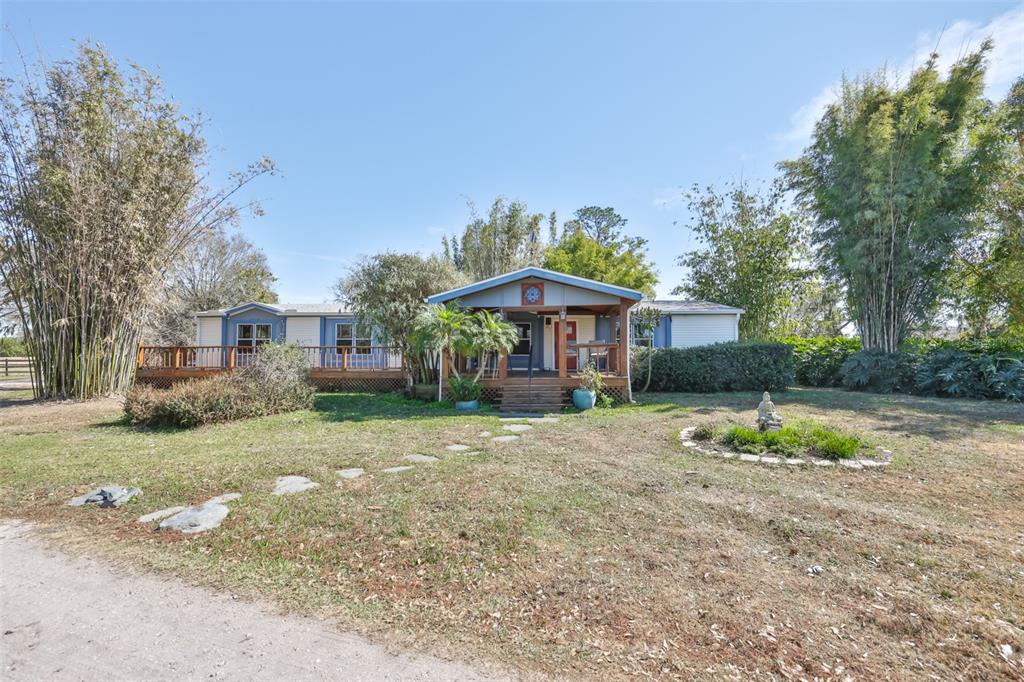 a front view of a house with a yard and trees