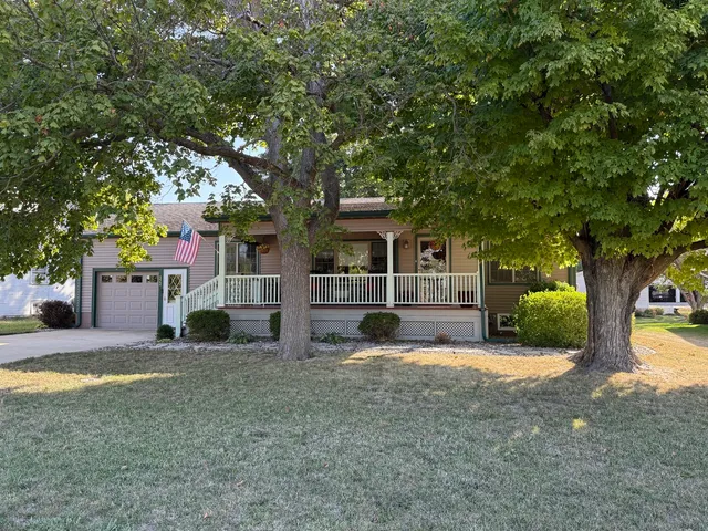 a view of a house with a large tree and a yard