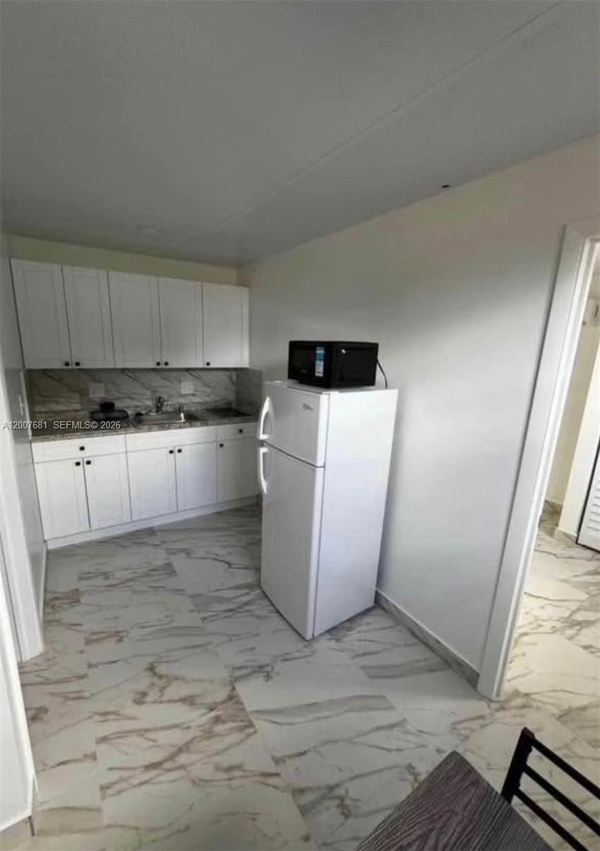 4721 Peters Road, Unit A Plantation, FL 33317 - Photo 2 of 5 a kitchen with a sink a stove and cabinets