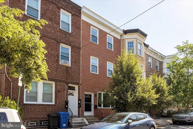a front view of a building with trees