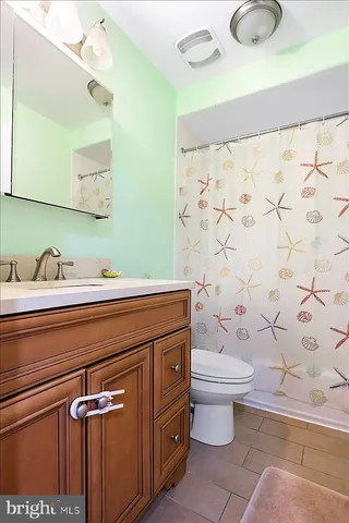 a bathroom with a granite countertop sink a toilet and a mirror