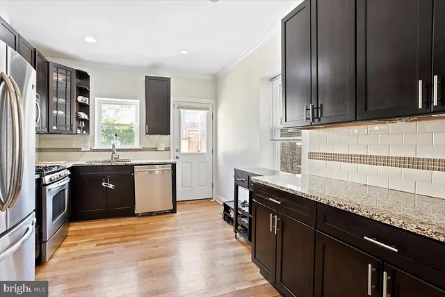 a kitchen with stainless steel appliances granite countertop a sink stove and refrigerator