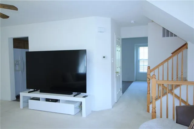 a living room with wooden floor and flat screen tv