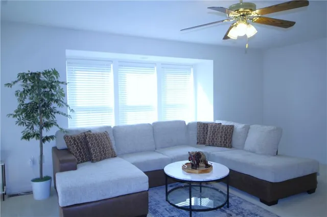 a living room with furniture a chandelier and a window
