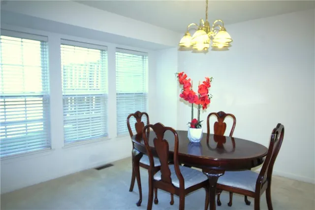 a view of a dining room with furniture and chandelier