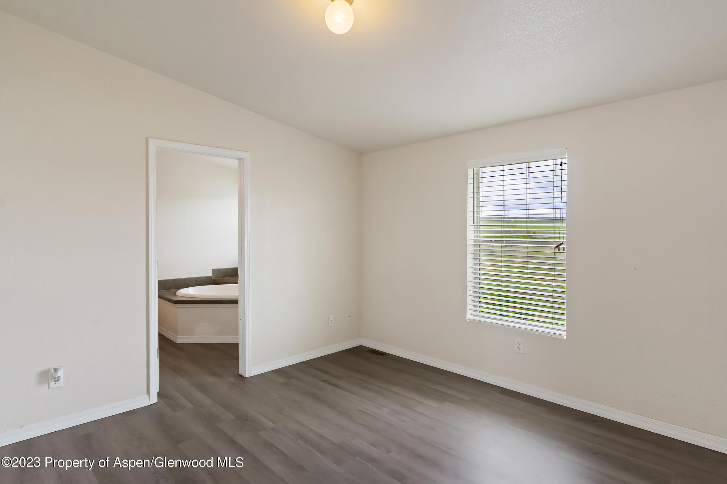378 Sunset Drive Craig, CO 81625 - Photo 11 of 22 wooden floor in an empty room with a window