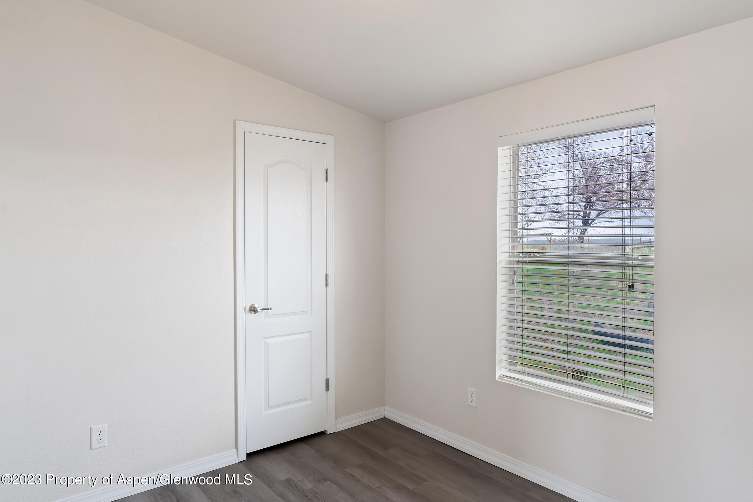 378 Sunset Drive Craig, CO 81625 - Photo 13 of 22 a view of an empty room with wooden floor and a window