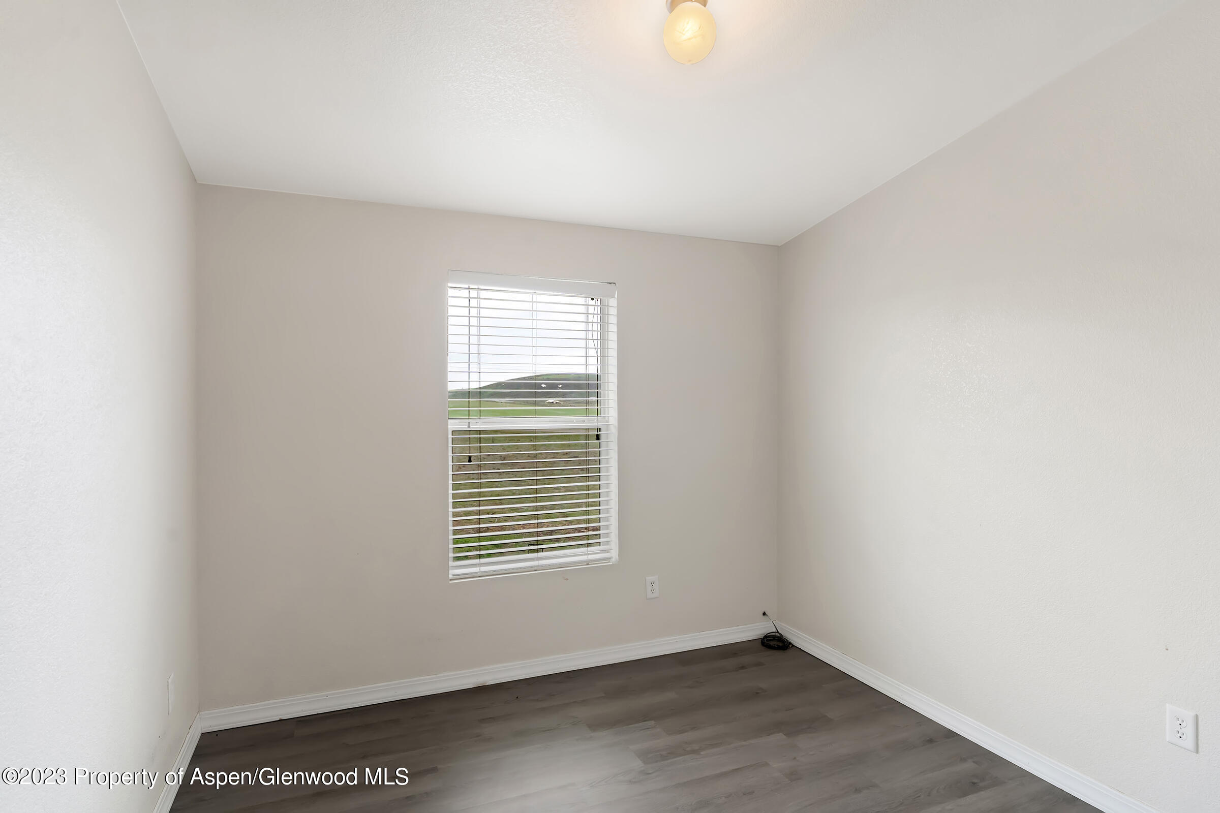 378 Sunset Drive Craig, CO 81625 - Photo 14 of 22 an empty room with wooden floor and windows