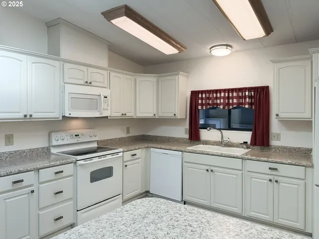 a kitchen with granite countertop a refrigerator and a sink