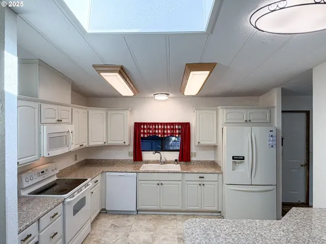 a kitchen with granite countertop a sink stove and cabinets