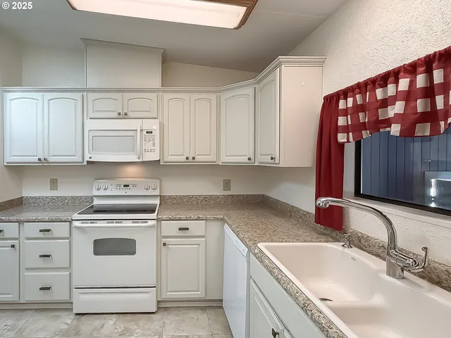 a kitchen with a table chairs sink and cabinets