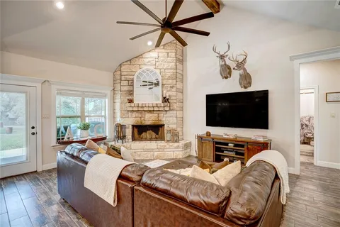 a living room with furniture a flat screen tv and a fireplace