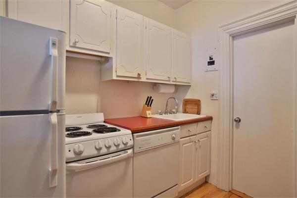 165 Beacon Street, Unit 8 Boston, MA 02116 - Photo 2 of 8 a kitchen with white cabinets and white appliances
