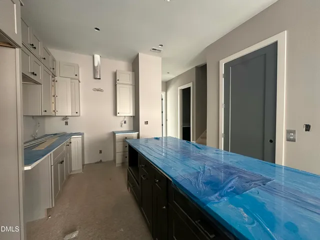 a kitchen with granite countertop a stove refrigerator and cabinets