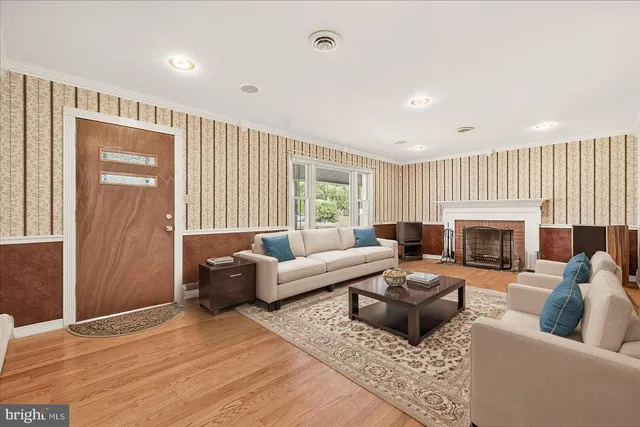 a kitchen with stainless steel appliances a refrigerator a stove a sink dishwasher a dining table and chairs with wooden floor