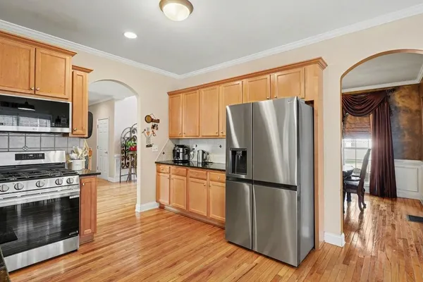 a kitchen with stainless steel appliances a refrigerator stove and wooden floor