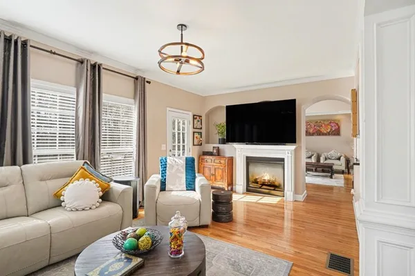 a living room with furniture a flat screen tv and a fireplace