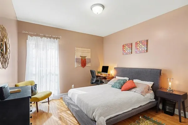 a bedroom with a bed and wooden floor