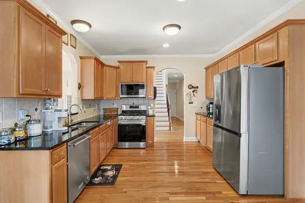a kitchen with stainless steel appliances a refrigerator sink and microwave