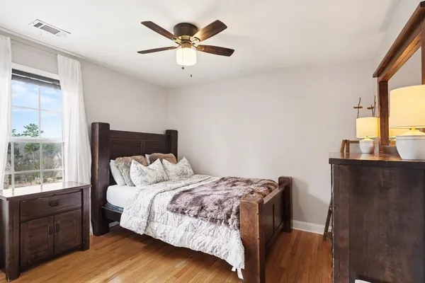 a bedroom with a bed and wooden floor