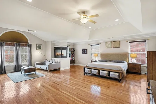 a spacious bedroom with a bed and wooden floor