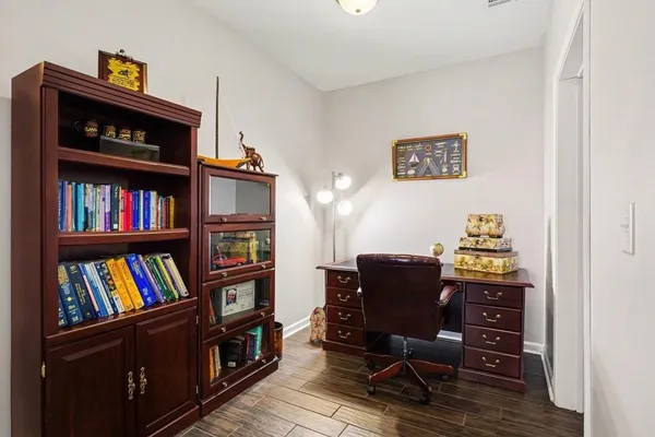 a view of a workspace with bookshelf and a window