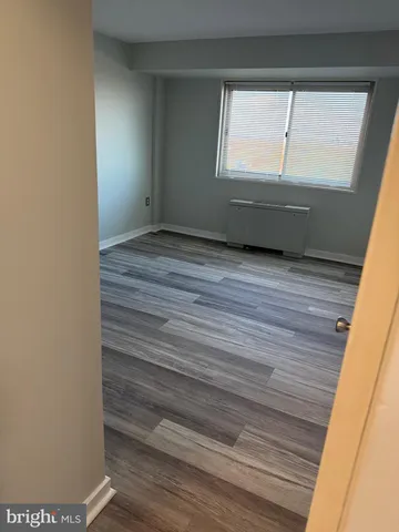 a view of room with window and wooden floor