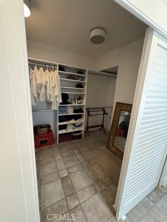 a view of walk in closet with clothes and shoes