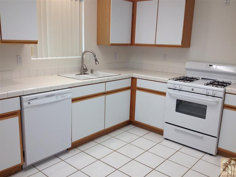68260 Risueno Road Cathedral City, CA 92234 - Photo 11 of 25 a kitchen with white cabinets and white appliances