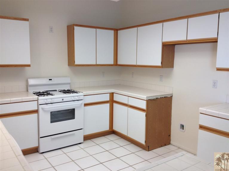 68260 Risueno Road Cathedral City, CA 92234 - Photo 12 of 25 a kitchen with white cabinets and white appliances
