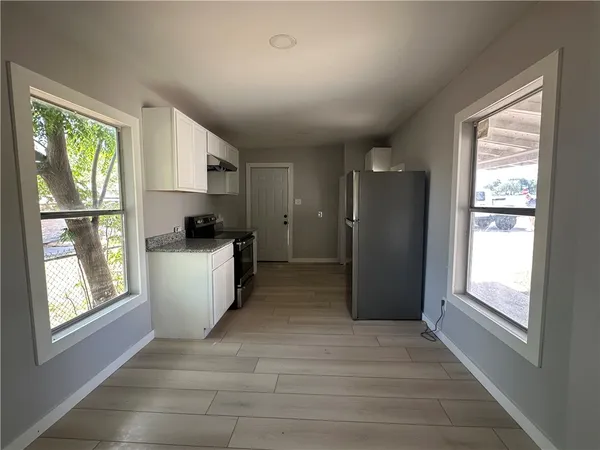 a view of kitchen with windows cabinets and front door