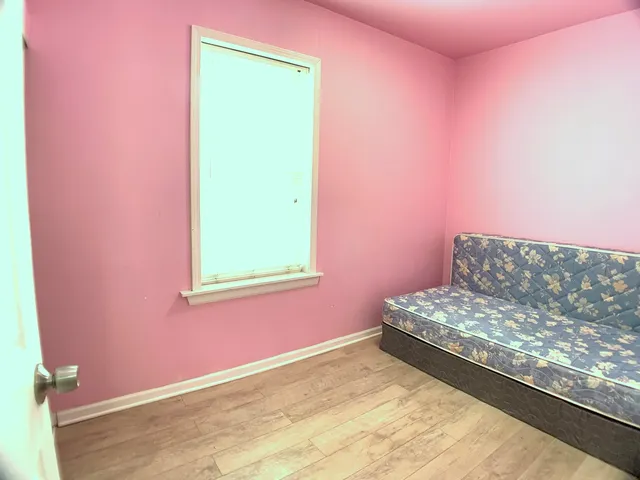 a view of a bedroom with a bed and a window