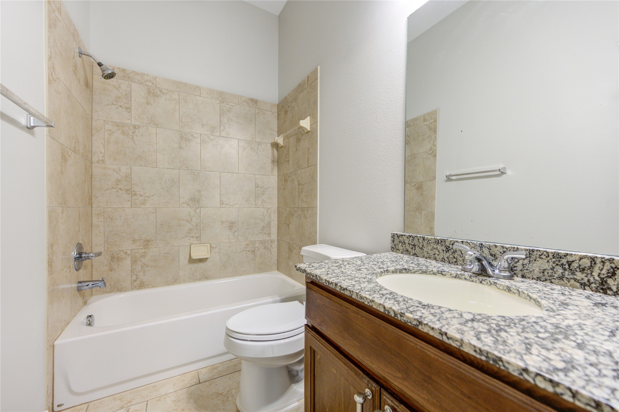 27407 Gatlin Lane Spring, TX 77386 - Photo 29 of 35 The secondary bath features a granite vanity, tiled tub and shower surround, and timeless finishes that blend style with everyday functionality.