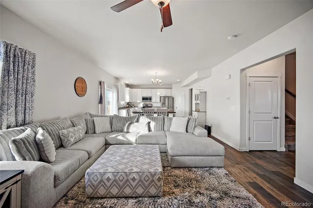 a kitchen with stainless steel appliances a dining table chairs and wooden floor