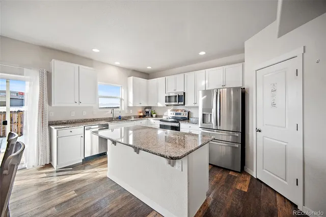 a kitchen with stainless steel appliances granite countertop a sink stove and cabinets