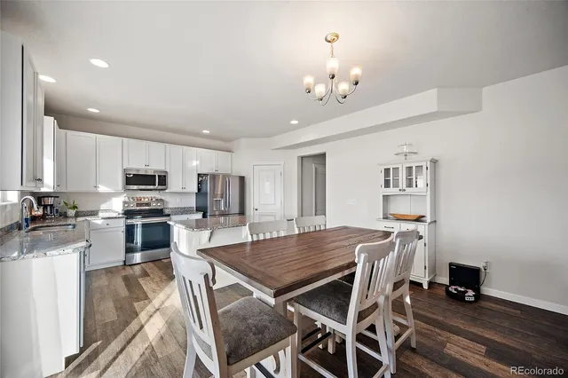 a kitchen with stainless steel appliances granite countertop a sink stove refrigerator and cabinets