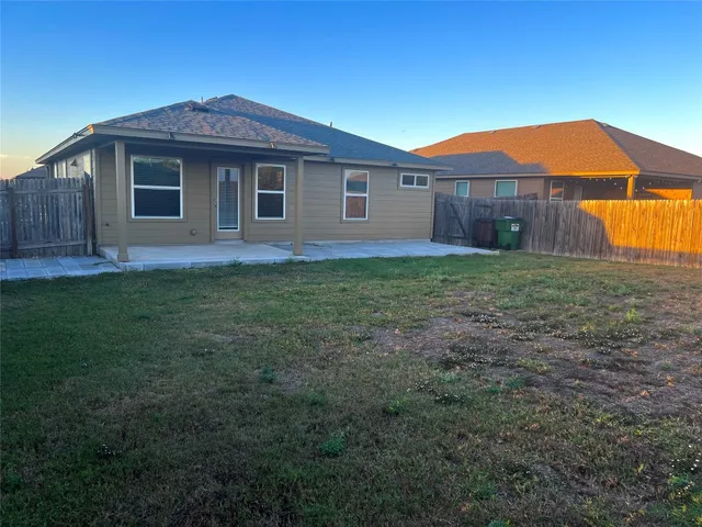 a small house with a small yard and large trees