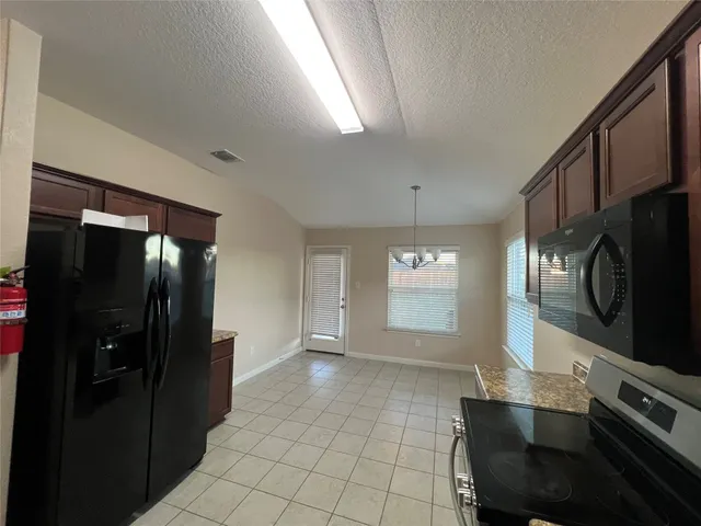 a view of a kitchen with furniture and stainless steel appliances