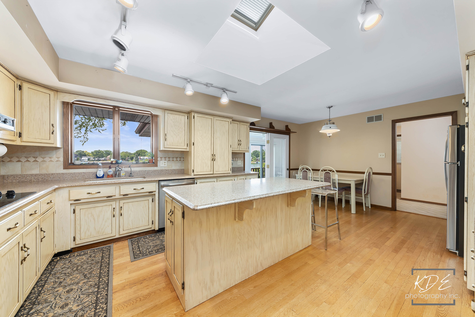 23211 Pilcher Road Plainfield, IL 60544 - Photo 19 of 58 a large kitchen with cabinets chairs and a view of living room