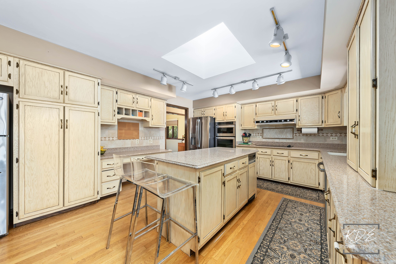 23211 Pilcher Road Plainfield, IL 60544 - Photo 20 of 58 a kitchen with stainless steel appliances granite countertop a refrigerator a stove and white cabinets with wooden floor