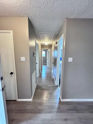 a view of a hallway with wooden floor
