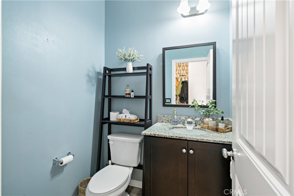 30271 Ramsay Drive Menifee, CA 92584 - Photo 14 of 34 a bathroom with a granite countertop sink and a mirror with toilet