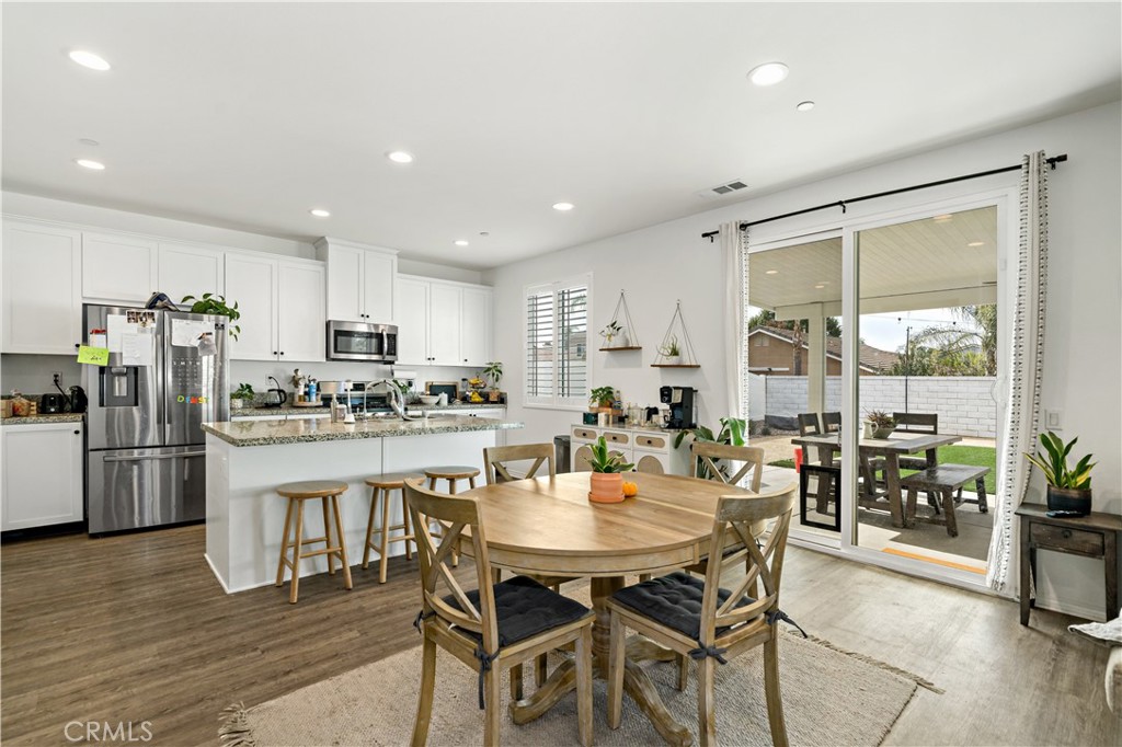 30271 Ramsay Drive Menifee, CA 92584 - Photo 8 of 34 a kitchen with a dining table chairs and refrigerator