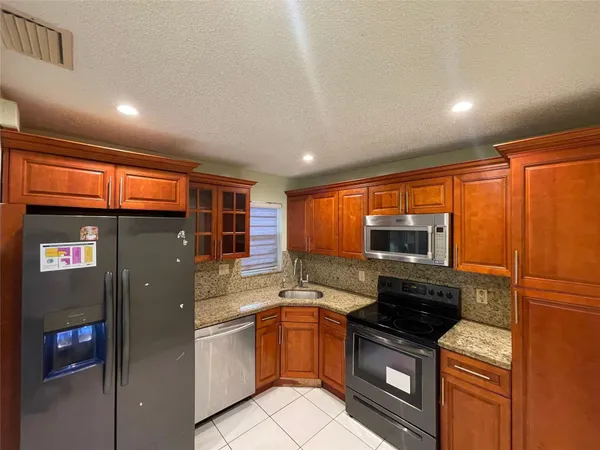a kitchen with stainless steel appliances granite countertop a refrigerator and a sink