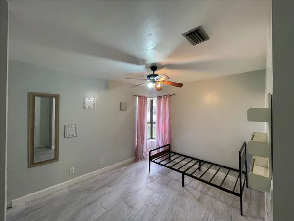 an empty room with windows and fan