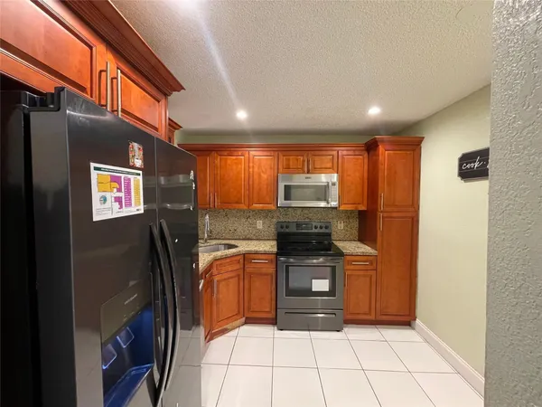 a kitchen with stainless steel appliances granite countertop a refrigerator and a stove