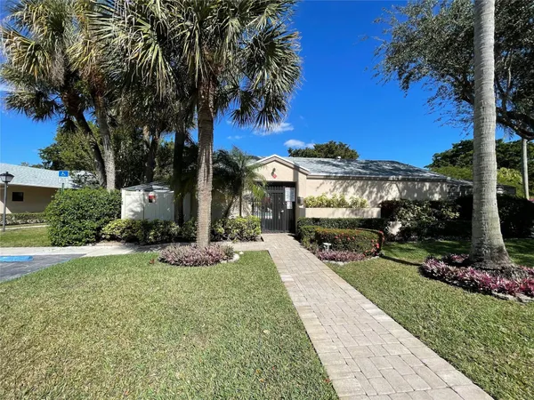 a front view of a house with a garden and yard