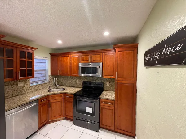 a kitchen with stainless steel appliances granite countertop a stove a sink and a microwave